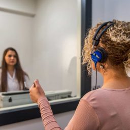 An audiologist performs a hearing test on a patient.