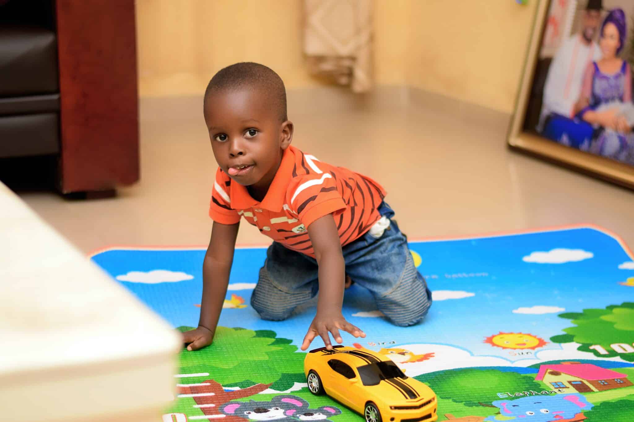 Little boy playing on a colorful mat in daycare.