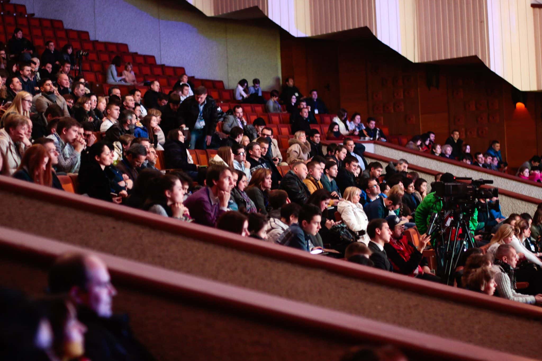 Group of people watching a performance in an auditorium.