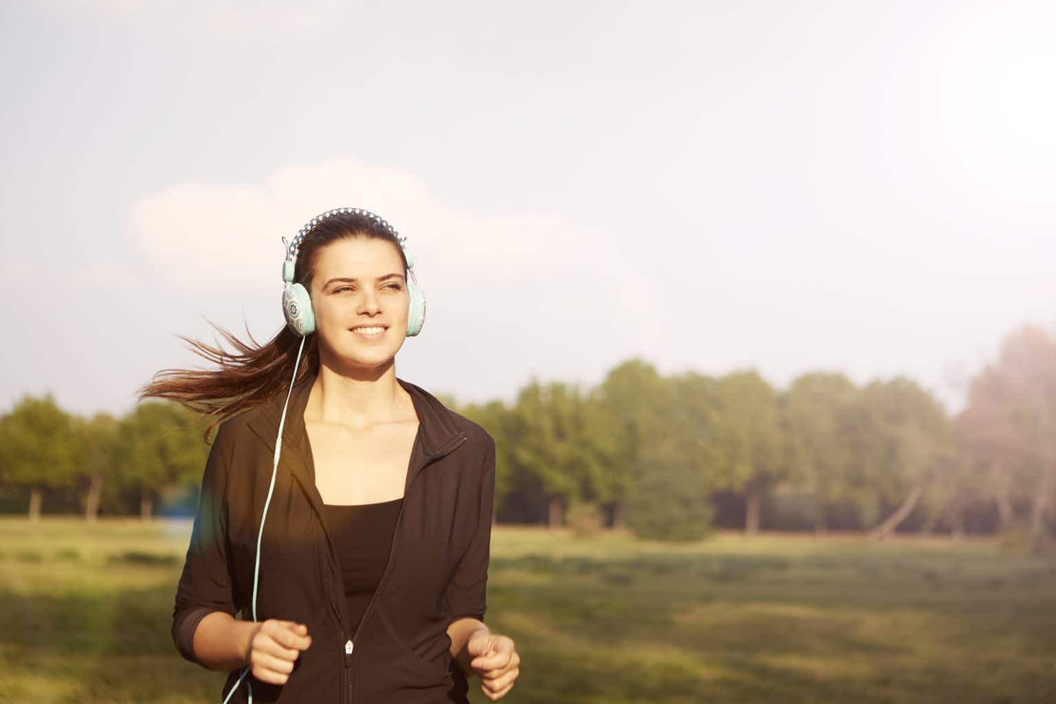 Woman jogging outside while wearing headphones.