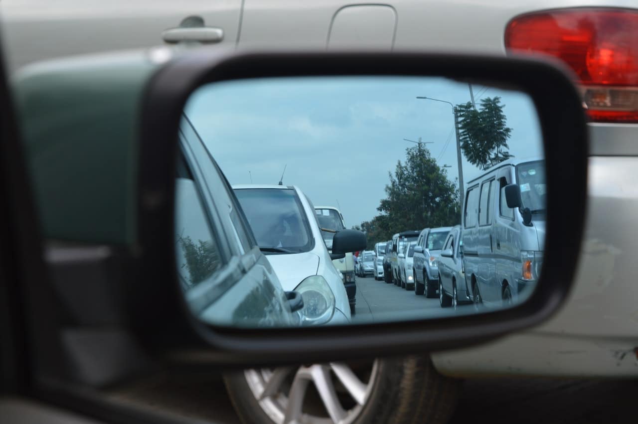 Traffic jam seen through a car mirror.