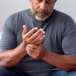 Man experiencing arthritis holding his hand