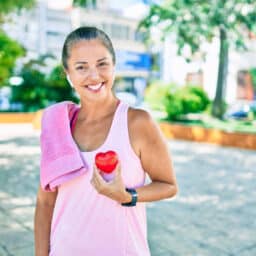Woman on a run holding a heart up to her chest.