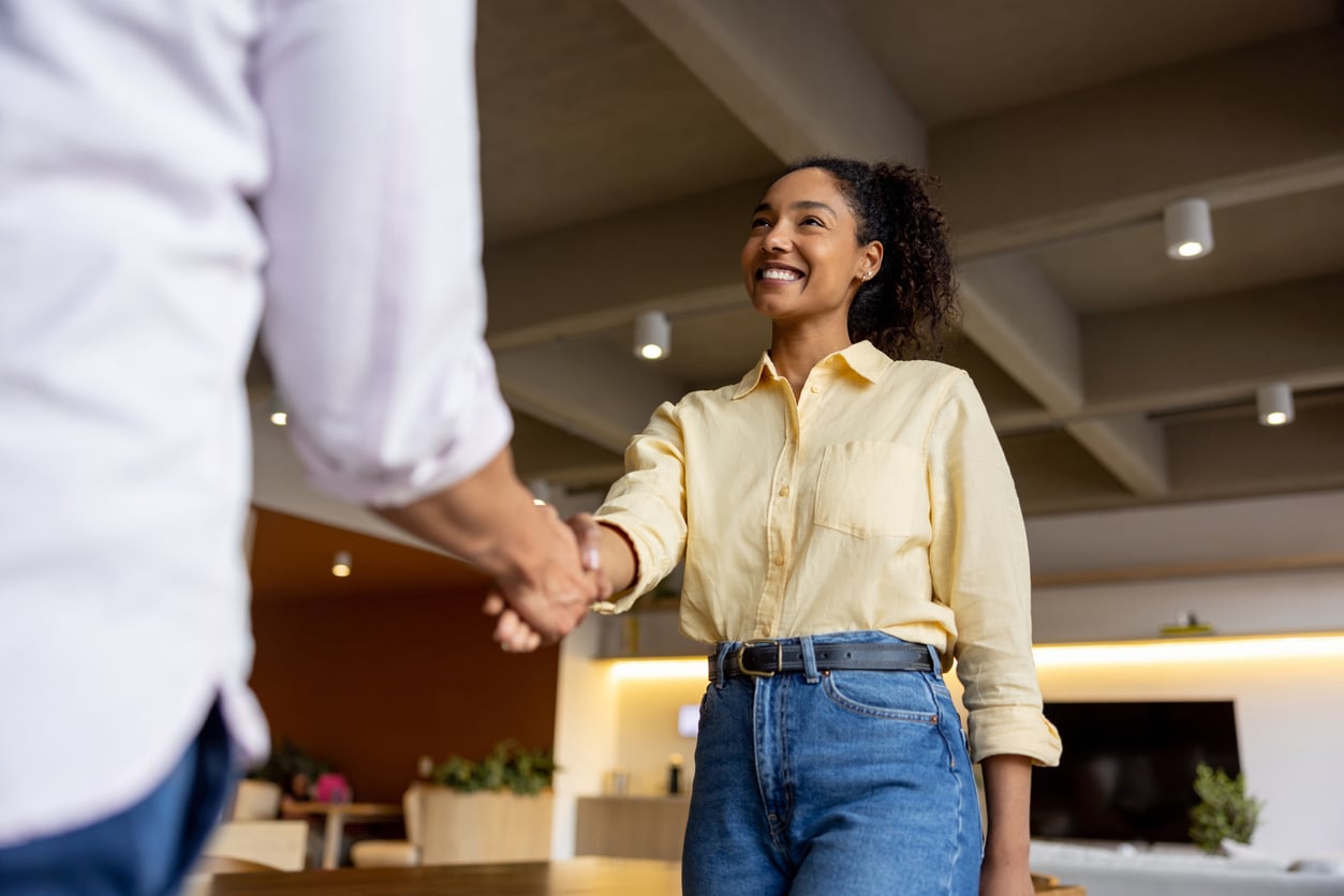 Woman shaking hands with her job interviewer.