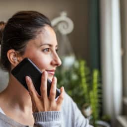 Woman talks on the phone with hearing aids