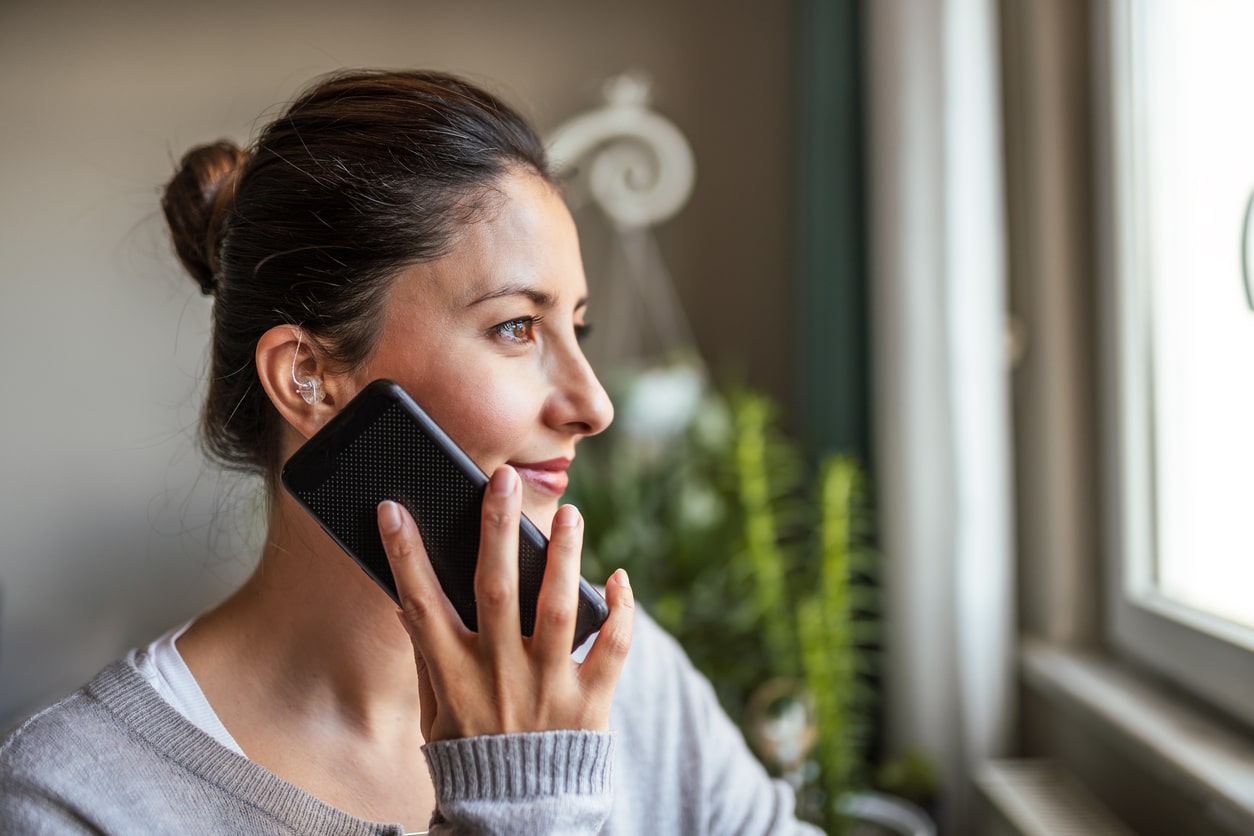 Woman talks on the phone with hearing aids