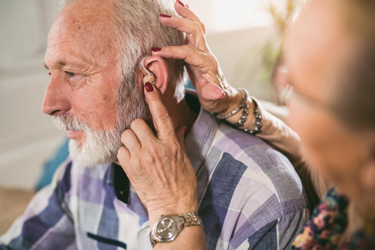 Senior man getting a new hearing aid.