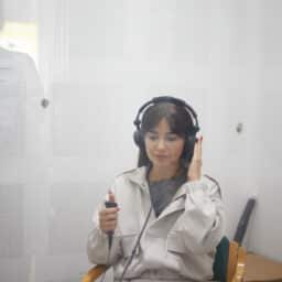 Woman wearing headphones taking a hearing test in a closed area