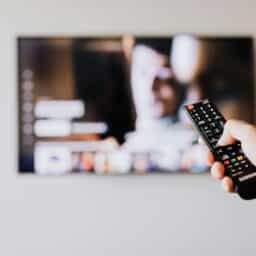 A remote held up in front of a television