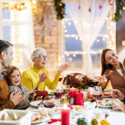 Happy family eating a holiday dinner in a well-decorated dining room.